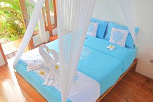 a bedroom with a bed with a swing at Lagoona Beach Bungalows - Eco Stay in Pangandaran