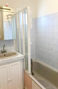 a bathroom with a sink and a bath tub at Les Goélands in Mimizan