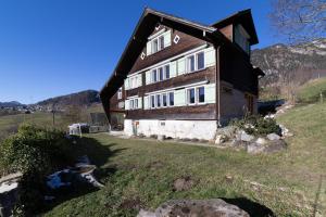 ein Haus auf einem Hügel mit einem Hof in der Unterkunft Sigerst in Wildhaus