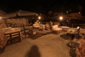 a group of chairs and tables on a patio at night at Harkasos Cave Hotel in Urgup