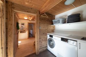 una lavadora y secadora en una cocina con paredes de madera en Sigerst, en Wildhaus