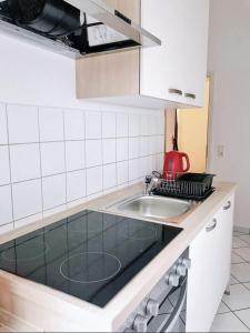 een keuken met een wastafel en een rode waterkoker bij Familienfreundliches Apartment im Zentrum für Geschäftsreisen und privat in Dresden