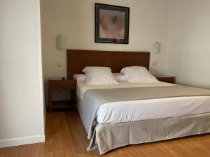 a neatly made bed in a bedroom at Rincón de Gran Vía in Madrid