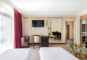 ヴヌーコヴォにあるSalut New Moscow Hotelのベッド2台とリビングルームが備わるホテルルームです。