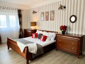 a bedroom with a large bed with red pillows at Słupsk forest PREMIUM LOVE APARTAMENT M5 - Kaszubska street 18 - Wifi Netflix Smart TV50 - double bathtub - up to 4 people full - pleasure quality stay in Słupsk