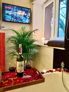 a bottle of wine and two glasses on a table at Słupsk forest PREMIUM LOVE APARTAMENT M5 - Kaszubska street 18 - Wifi Netflix Smart TV50 - double bathtub - up to 4 people full - pleasure quality stay in Słupsk
