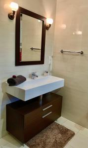 ein Badezimmer mit einem weißen Waschbecken und einem Spiegel in der Unterkunft Słupsk forest PREMIUM LOVE APARTAMENT M5 - Kaszubska street 18 - Wifi Netflix Smart TV50 - double bathtub - up to 4 people full - pleasure quality stay in Słupsk