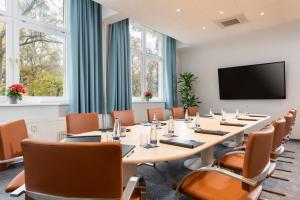 a conference room with a large table and chairs at Hotel Aquino Berlin in Berlin