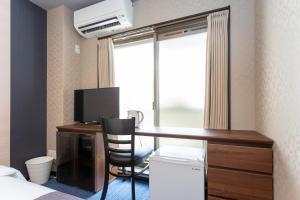 a hotel room with a desk with a computer and a window at SlowTime Hotel Kyoto in Kyoto