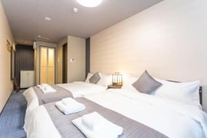 a bedroom with two beds with white towels on them at SlowTime Hotel Kyoto in Kyoto