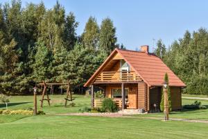 a log cabin with a playground and a swing at Vila Karališkis in Karališkiai