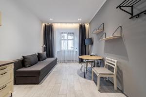 ein Wohnzimmer mit einem Sofa und einem Tisch in der Unterkunft Staroevreyska Apartment B in Lwiw