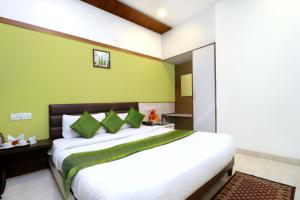 a bedroom with a large bed with green walls at Hotel Seven in Chandīgarh