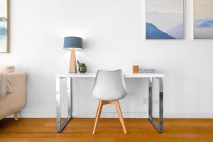 a white desk with a chair and a lamp at Waterloo St Apartments by Urban Rest in Sydney