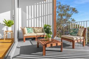 un patio con 2 sedie e un tavolino da caffè di Waterloo St Apartments by Urban Rest a Sydney