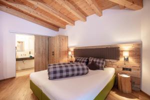 Schlafzimmer mit einem großen Bett und Holzwänden in der Unterkunft Apart Auszeit in Sölden