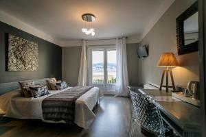 a bedroom with a bed and a desk and a window at Hôtel Spunta Di Mare in Ajaccio