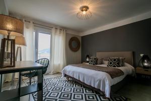 a bedroom with a bed and a desk and a window at Hôtel Spunta Di Mare in Ajaccio