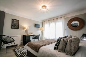 a bedroom with a bed and a window and a desk at Hôtel Spunta Di Mare in Ajaccio