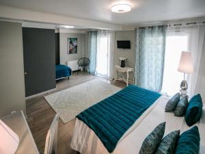 a bedroom with a large bed with a blue blanket at Hôtel Spunta Di Mare in Ajaccio