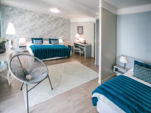 a bedroom with two beds and a chair in it at Hôtel Spunta Di Mare in Ajaccio