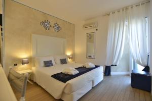 a bedroom with a bed with two towels on it at UNAHOTELS Club Hotel Ancora in Stintino