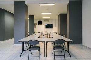 une salle de conférence avec une table et des chaises blanches dans l'établissement Hôtel Spunta Di Mare, à Ajaccio