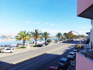 a street with palm trees and a road with cars at Casa Avenida in Lagos