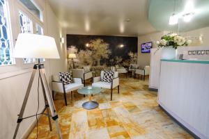 a room with a waiting room with chairs and a table at Hôtel Spunta Di Mare in Ajaccio