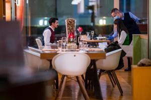 un gruppo di persone seduti a un tavolo in un ristorante di Hotel Delfino Lugano a Lugano