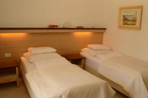 - 2 lits dans une chambre d'hôtel avec des draps blancs dans l'établissement Vila Park B&B - Adults Only, à Bohinj