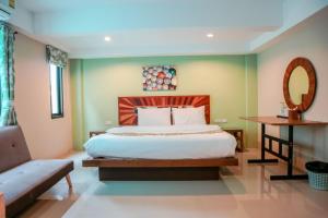een slaapkamer met een bed, een bank en een spiegel bij Tree Retro Hotel Chiang Mai in Chiang Mai +27 foto's