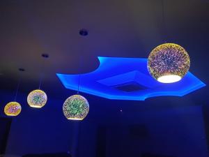 a group of lights hanging from a blue ceiling at LEX Trend Hotel in Irpin
