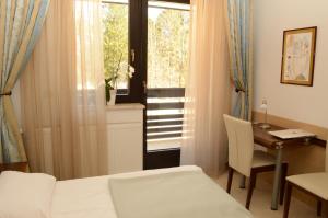 - une chambre avec un lit, un bureau et une fenêtre dans l'établissement Vila Park B&B - Adults Only, à Bohinj