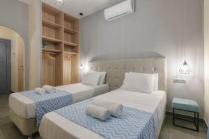 a bedroom with two beds with towels on them at Barcode Studios in Laganas
