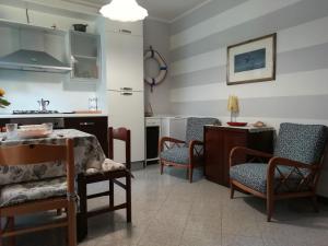 sala de estar con sillas, mesa y cocina en Da Antonietta by Holiday World, en Chiavari