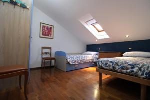 een kamer met 2 bedden en een tafel en een stoel bij Da Antonietta by Holiday World in Chiavari