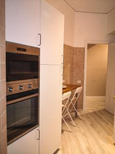 cocina con fogones y mesa de madera en La casa di Fabia - Home suite, en Messina