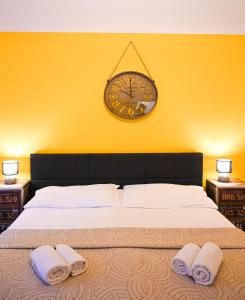 a bedroom with a large bed and a clock on the wall at Backpacker Apartment Hofburg in Vienna