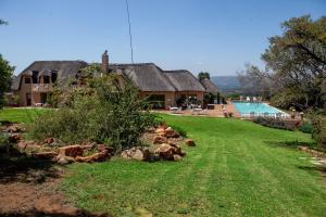 a house with a yard and a swimming pool at Steynshoop Mountain Lodge (Hotel) in Hekpoort