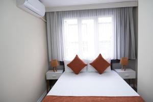 Un dormitorio con una cama blanca con almohadas y una ventana en GREEN SUITES BURSA en Bursa