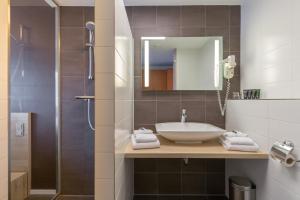 a bathroom with a sink and a shower at de Baak Seaside in Noordwijk aan Zee