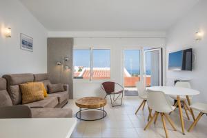 a living room with a couch and a table and chairs at Haciendas IV in Adeje