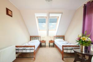 Zimmer im Dachgeschoss mit 2 Betten und einem Tisch in der Unterkunft Hotel Wartosław in Wronke