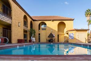 a swimming pool in front of a building at Rodeway Inn & Suites Colton-Riverside in Colton