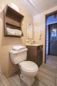 a bathroom with a toilet a sink and a mirror at Posada del MAR in Ensenada