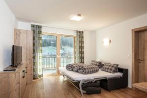 a living room with a couch and a television at Apart Auszeit in S&ouml;lden