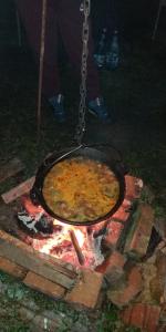 um pote de comida está cozinhando sobre uma fogueira em Albinuta Guesthouse em Ozun