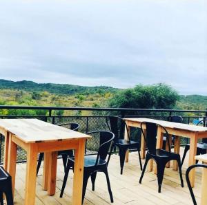 two tables and chairs on a deck with a view at Posada Tampu Kuntur in San Antonio de Arredondo