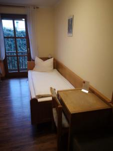 Dormitorio pequeño con cama y mesa en Gasthof Metzgerwirt, en Regenstauf